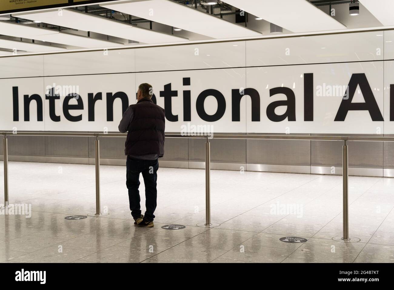 man waiting at international arrivals hall for traveller  clients flew into London Heathrow airport, England Stock Photo