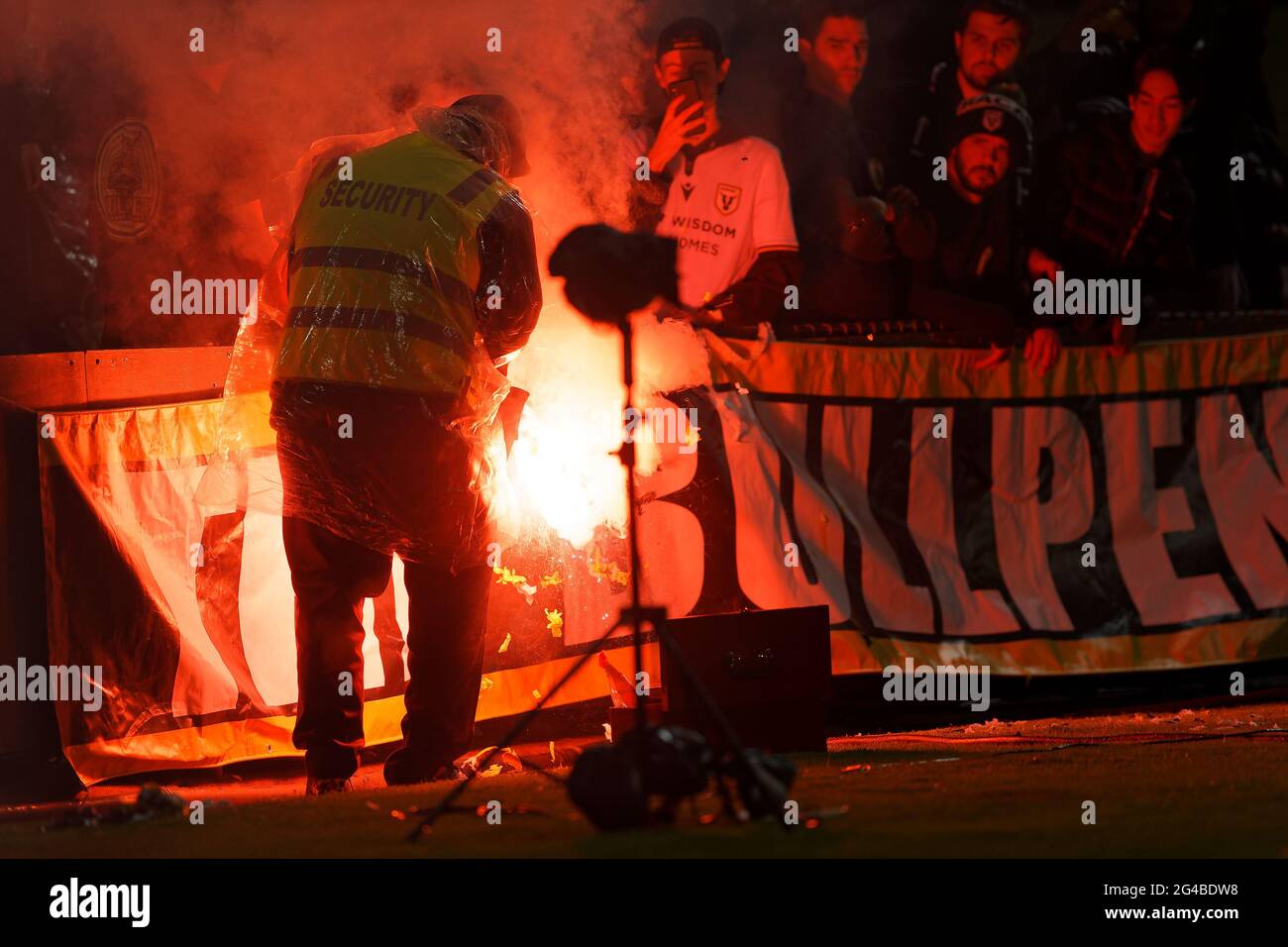 Sydney, Australia. 20th June, 2021. A security guard is attempting to put out the flare that was set off in the crowd during the A-League semi-final soccer match between Melbourne City and Macarthur on June 20, 2021 at Netstrata Jubilee Stadium in Sydney, Australia Credit: IOIO IMAGES/Alamy Live News Stock Photo