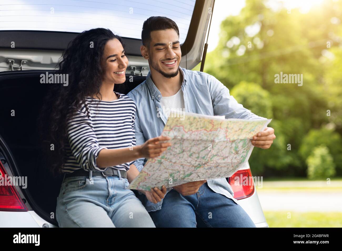 Loving middle-eastern couple watching map while having break Stock Photo