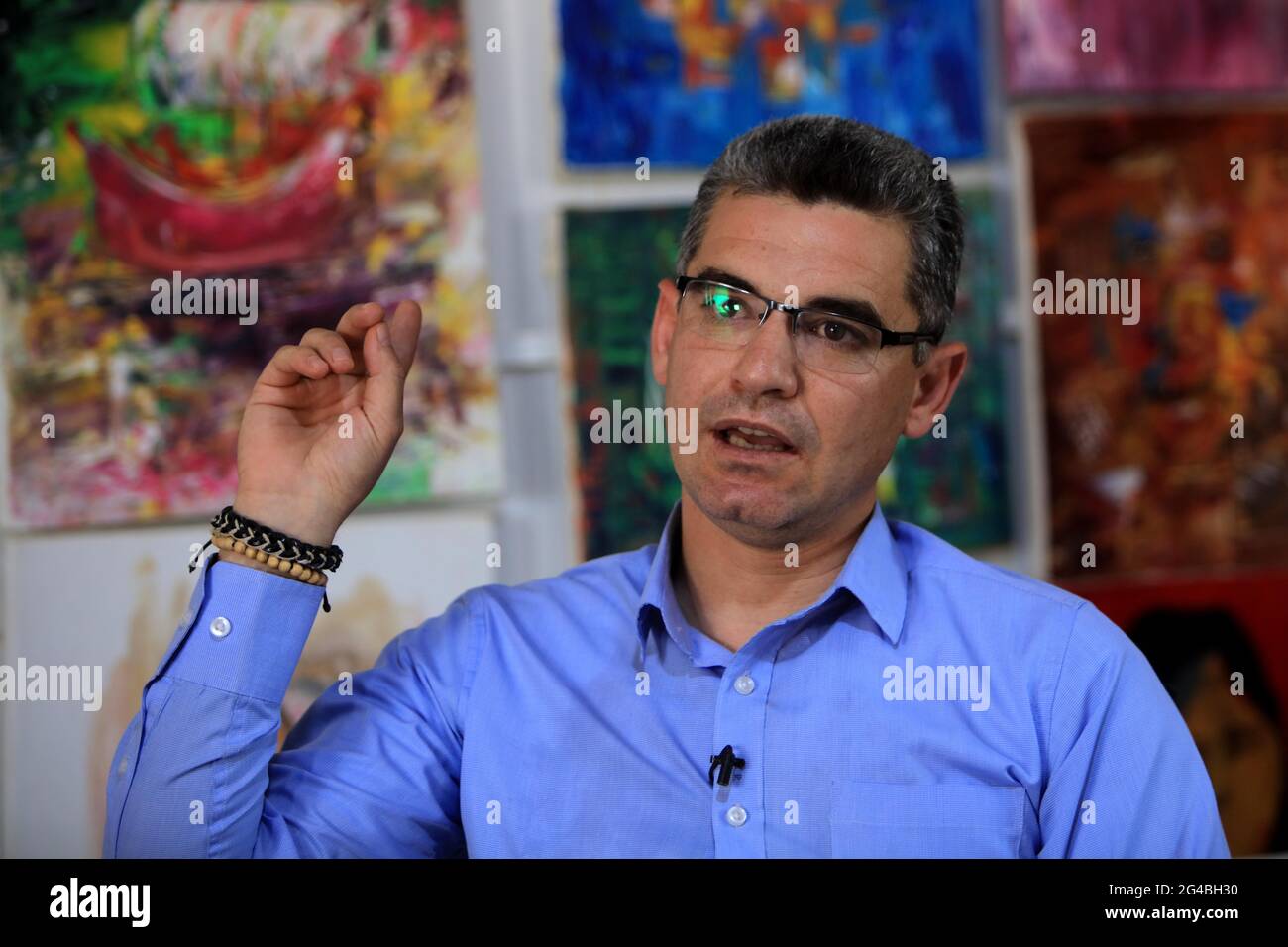 (210620) -- ZAATARI CAMP, June 20, 2021 (Xinhua) -- Mohamed Jokhadar speaks during an interview with Xinhua at the Zaatari refugee camp, Jordan, June 17, 2021. Mohamed Jokhadar, a 35-year-old Syrian artist who lives in Jordan's Zaatari Camp for Refugees, uses his painting skills not only to restore hope among Syrian refugees but also to educate and empower them to realize a better future.TO GO WITH 'Feature: Syrian artist paints to revive hope among refugees in Jordan' (Photo by Mohammad Abu Ghosh/Xinhua) Stock Photo