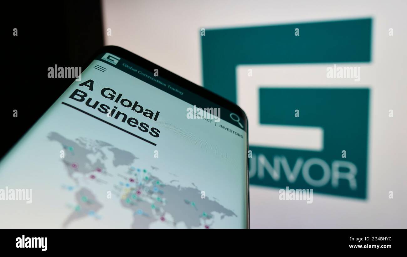 Cellphone with webpage of commodity trading company Gunvor Group Ltd on screen in front of business logo. Focus on center of phone display. Stock Photo