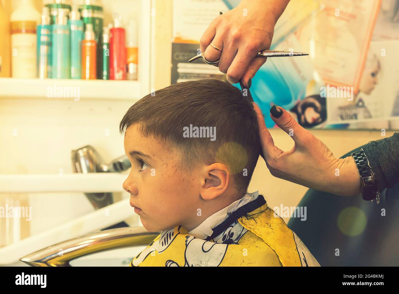 little boy having a haircut at hair salon..Children hairdresser with  scissors and comb is cutting little boy. Contented cute preschooler boy  getting Stock Photo - Alamy