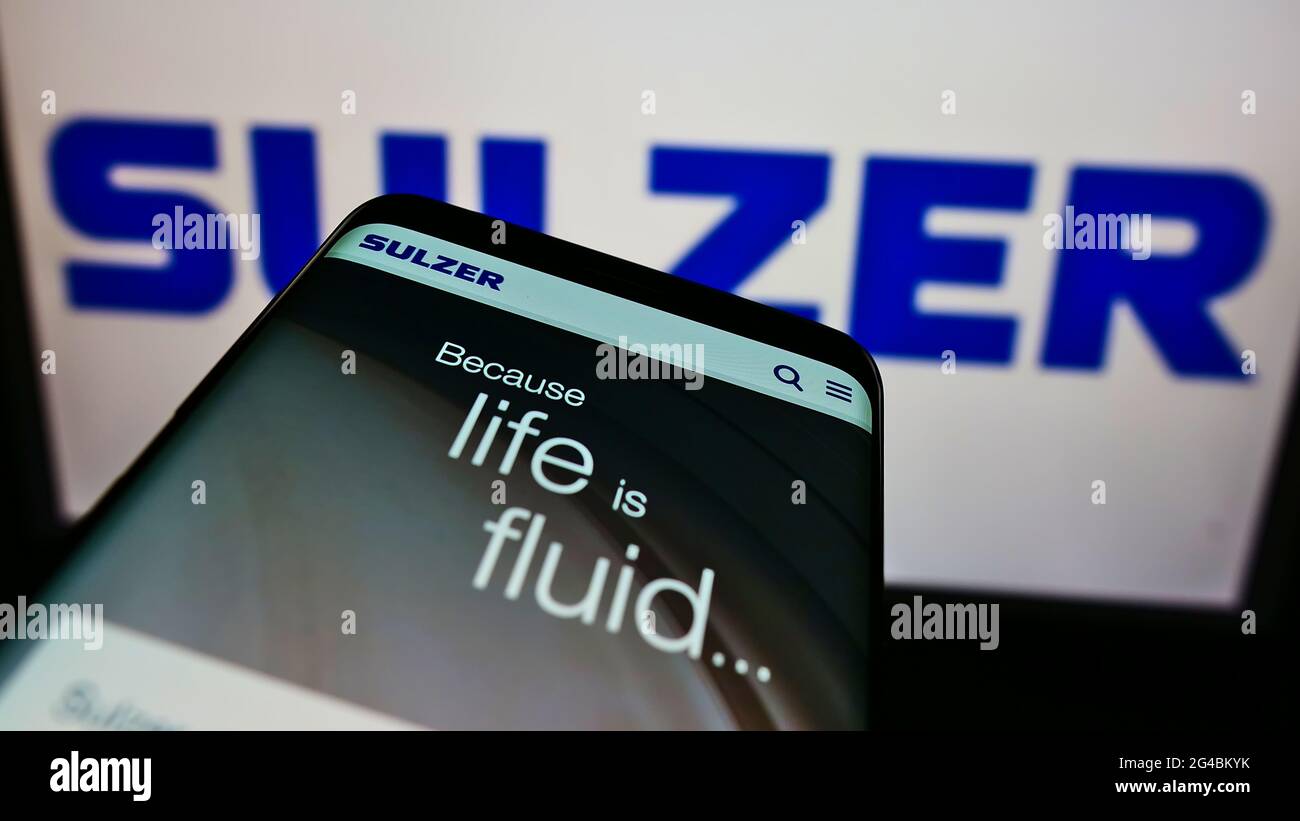 Smartphone with website of Swiss engineering company Sulzer AG on screen in front of business logo. Focus on top-left of phone display. Stock Photo