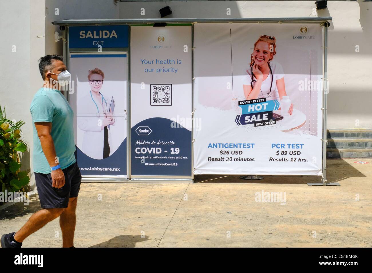 Tourist walks pass at Covid-19 testing mobile unit in Cancun Mexico Stock Photo