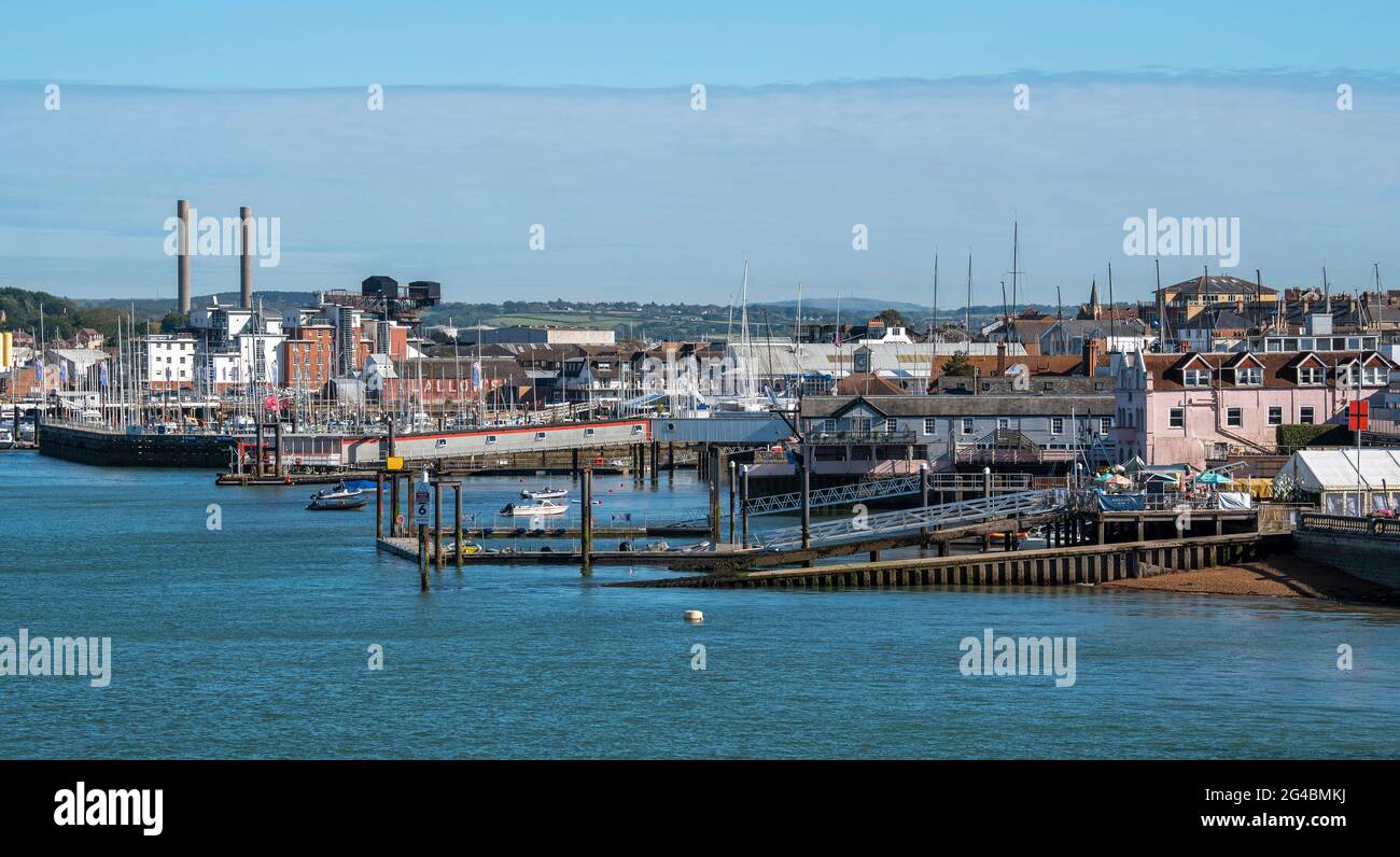 Cowes, Isle of Wight, England, UK. 2021. Cowes viewed along the waterfront of the River Medina showing chimneys of the power station, marinas and land Stock Photo