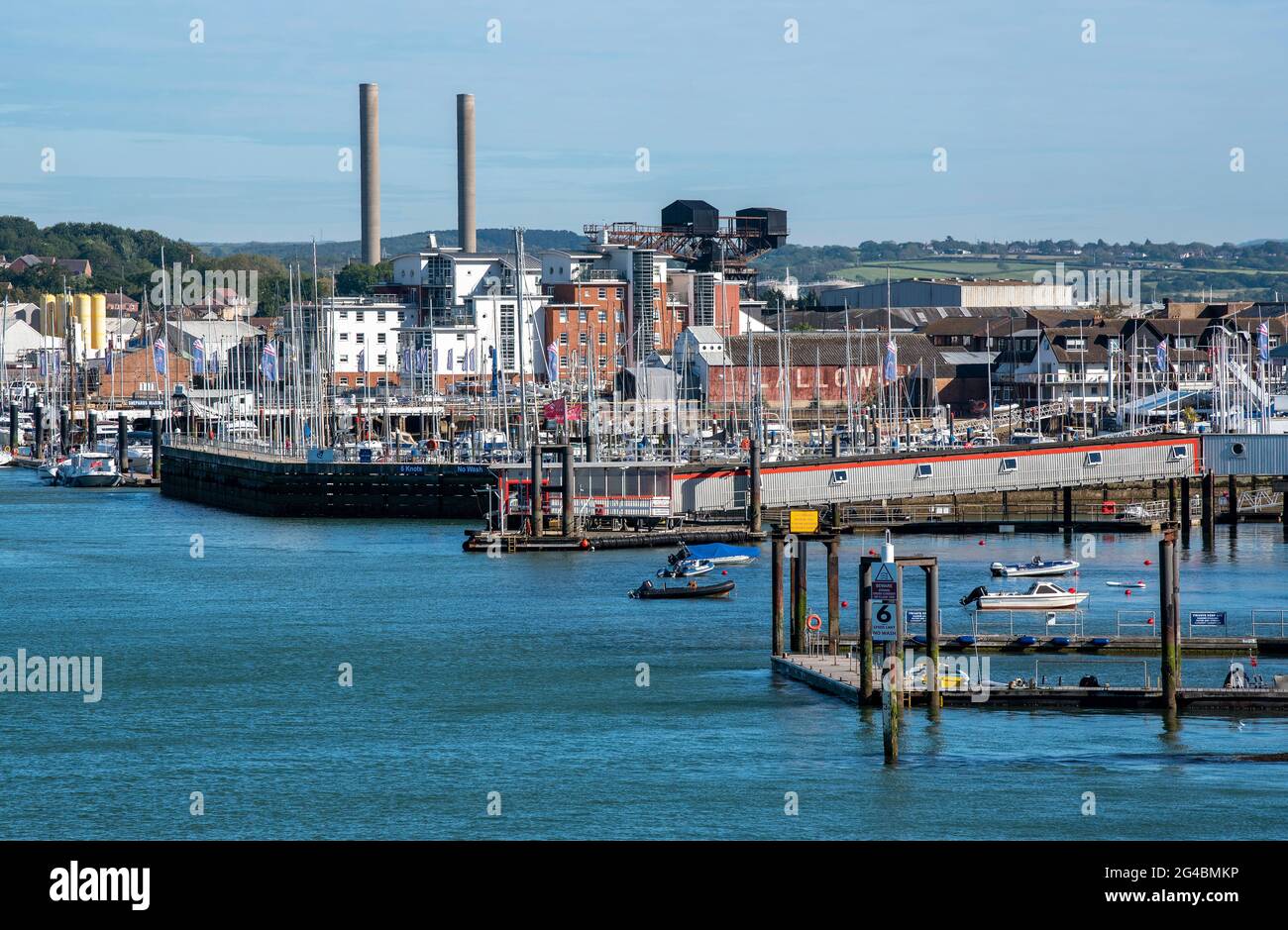 Cowes, Isle of Wight, England, UK. 2021. Cowes viewed along the waterfront of the River Medina showing chimneys of the power station, marinas and land Stock Photo