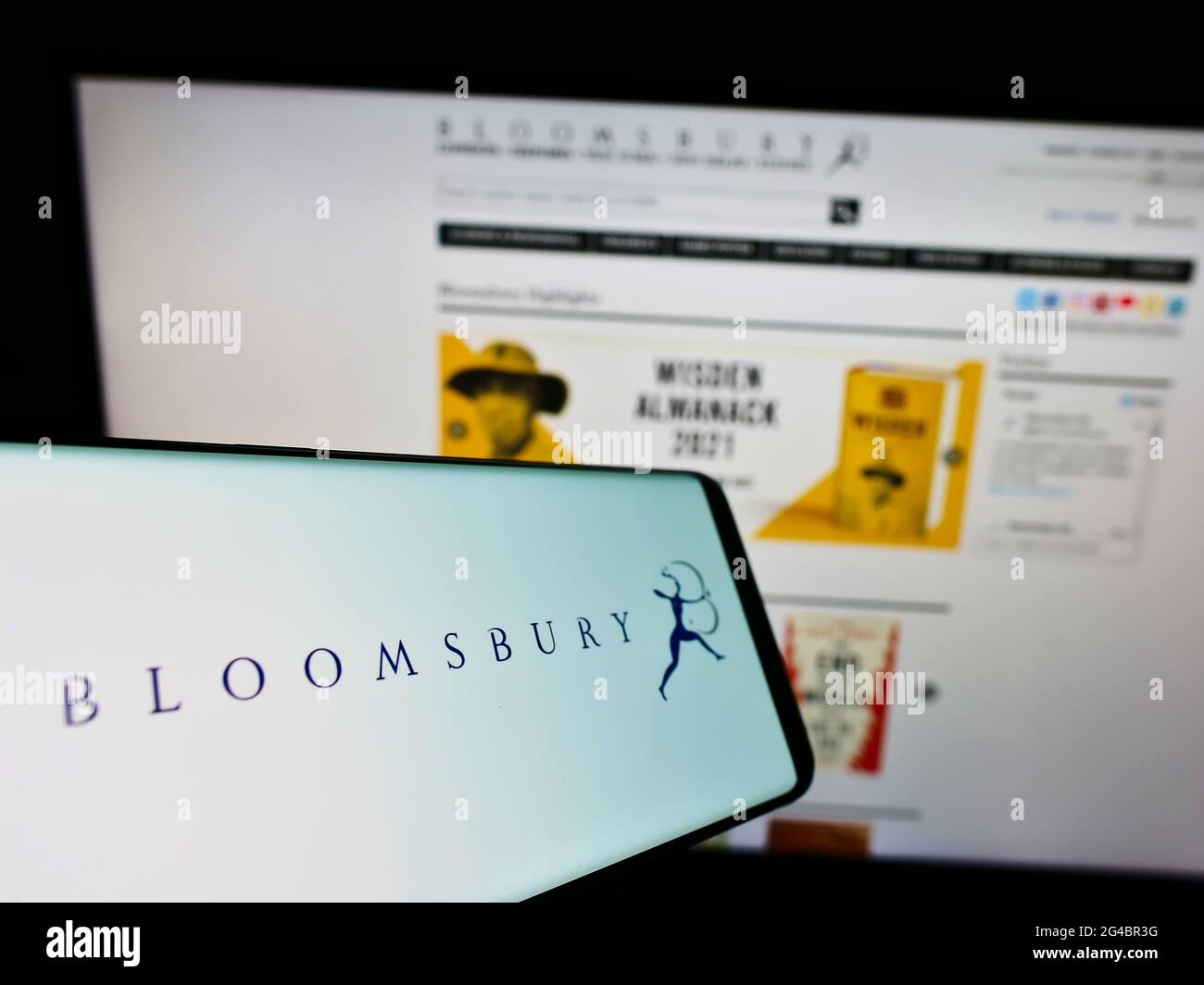 Smartphone with logo of British publisher Bloomsbury Publishing plc on screen in front of business website. Focus on center-right of phone display. Stock Photo
