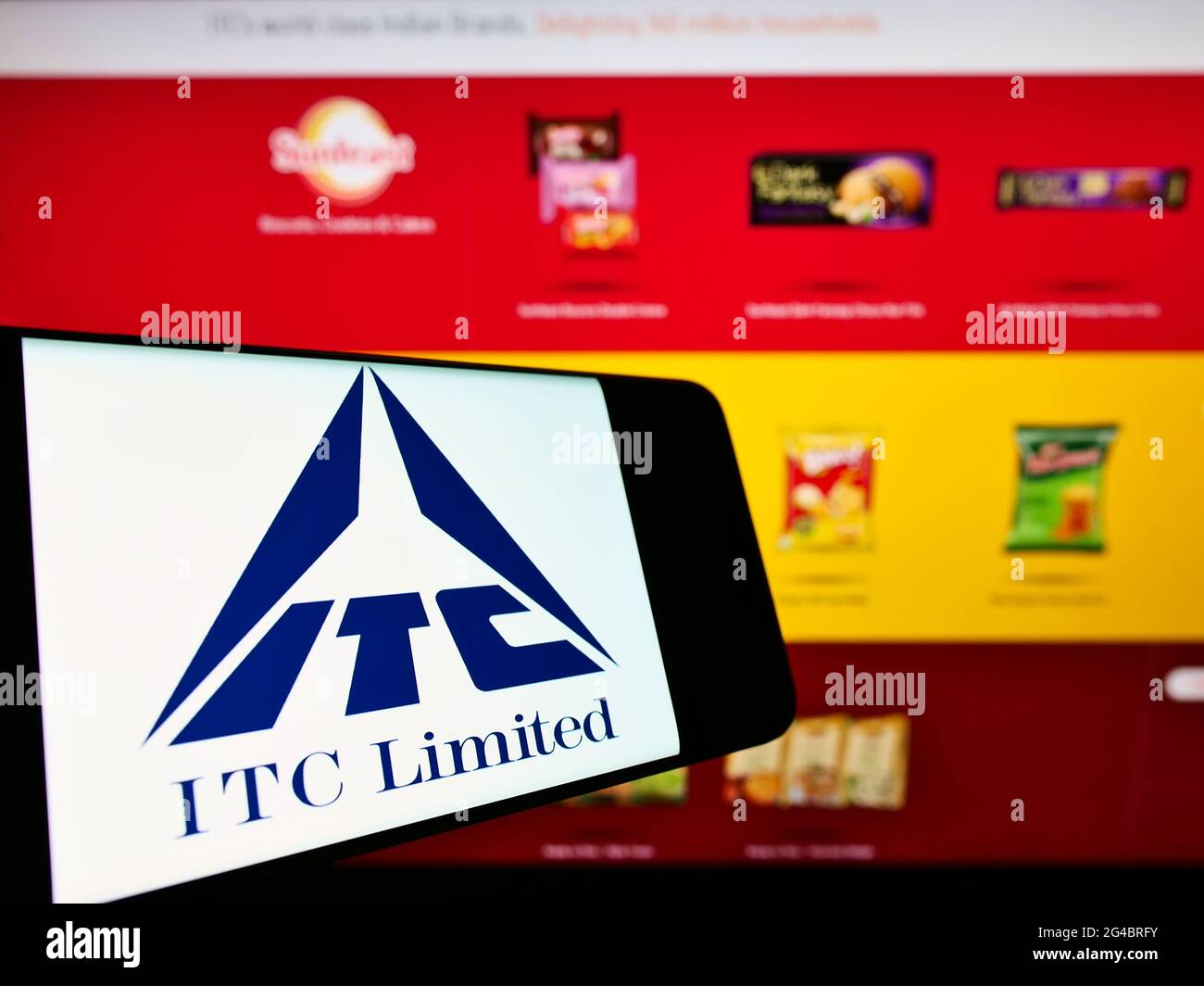 Cellphone with company logo of Indian conglomerate ITC Limited on screen in front of business website. Focus on center-right of phone display. Stock Photo