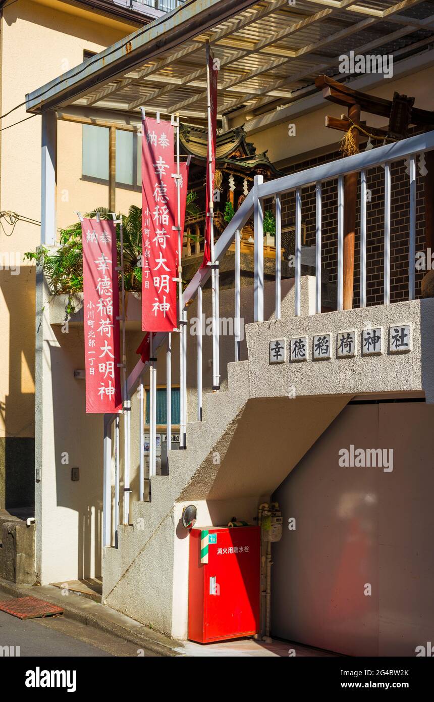 Spirituality in Japan. The Kotoku Inari Shrine, one of the smallest temple incorporated in a Tokyo's modern building Stock Photo