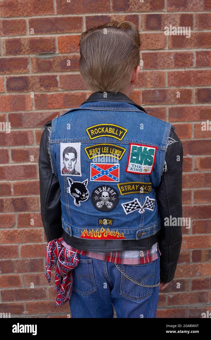 Rear view of young boy wearing jeans vest and patches Stock Photo