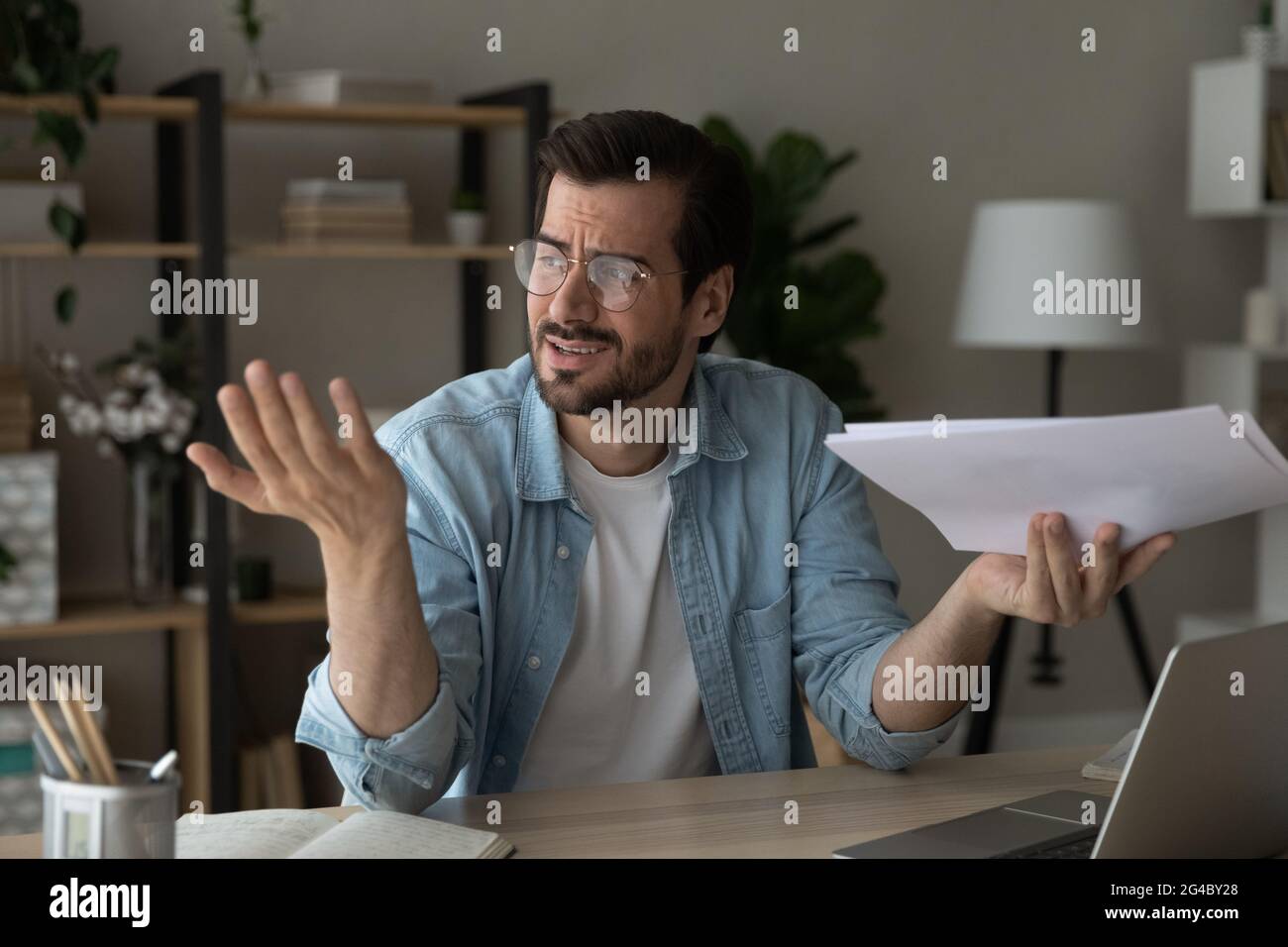 Frustrated young man feeling stressed of reading bad news. Stock Photo