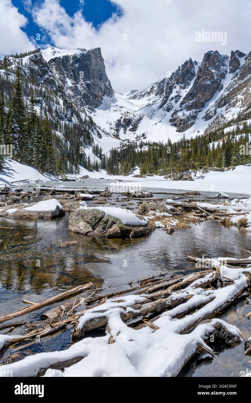 Spring Dream Lake - Wide-angle vertical view of still-mostly-frozen Dream Lake, with Hallett Peak and Flattop Mountain towering at shore, RMNP, CO, US. Stock Photo