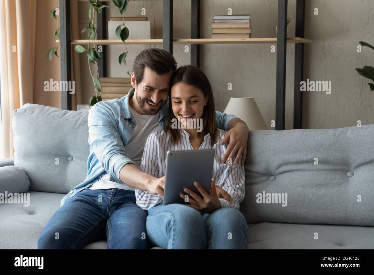 Affectionate bonding happy couple using digital tablet. Stock Photo