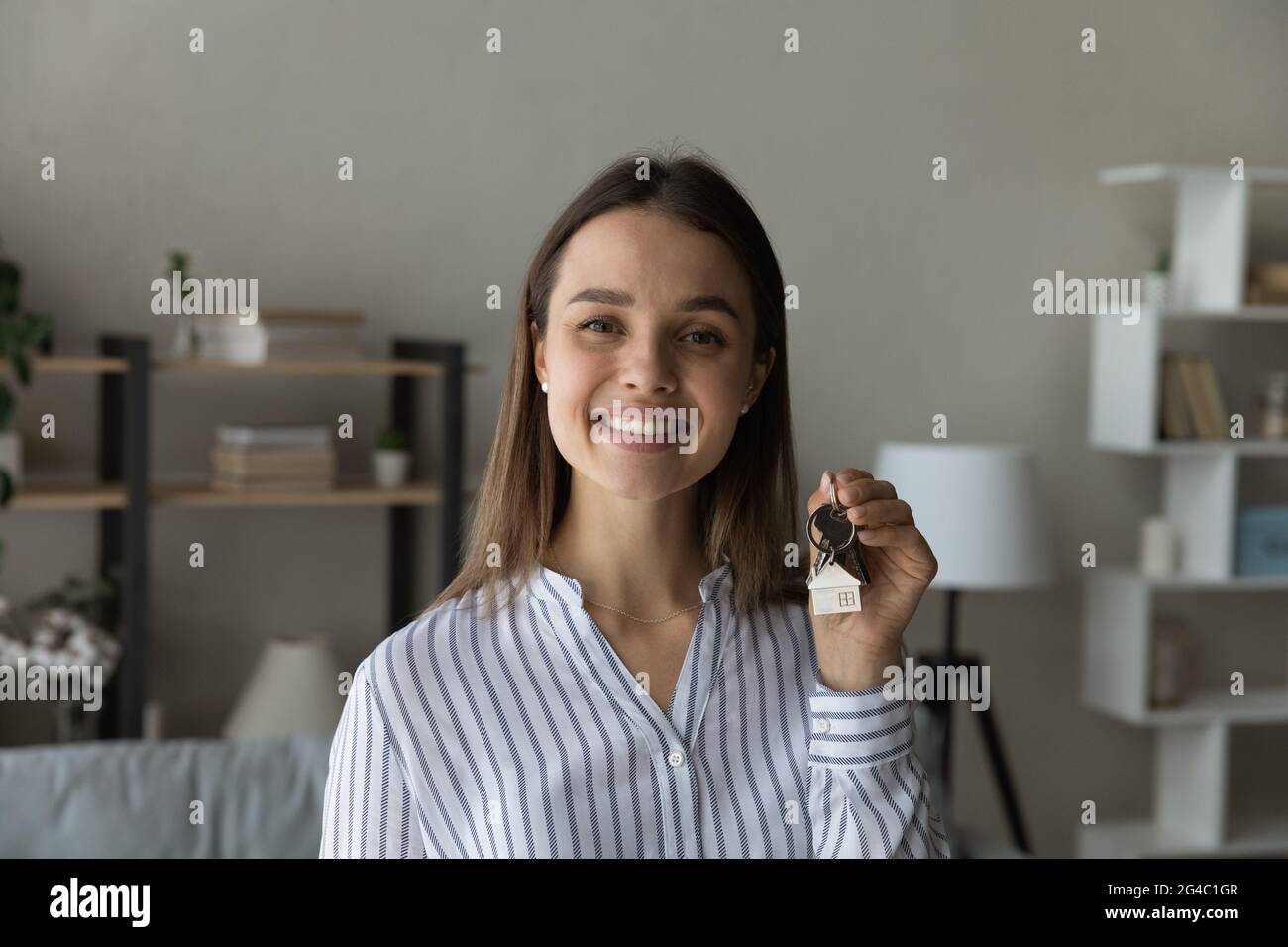 Sincere happy young woman holding key in hands Stock Photo - Alamy