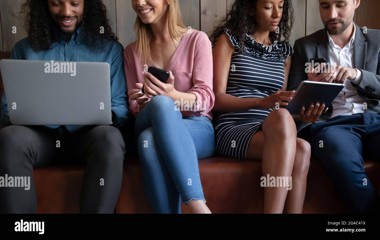 Cropped image young friendly multiracial people using different gadgets. Stock Photo