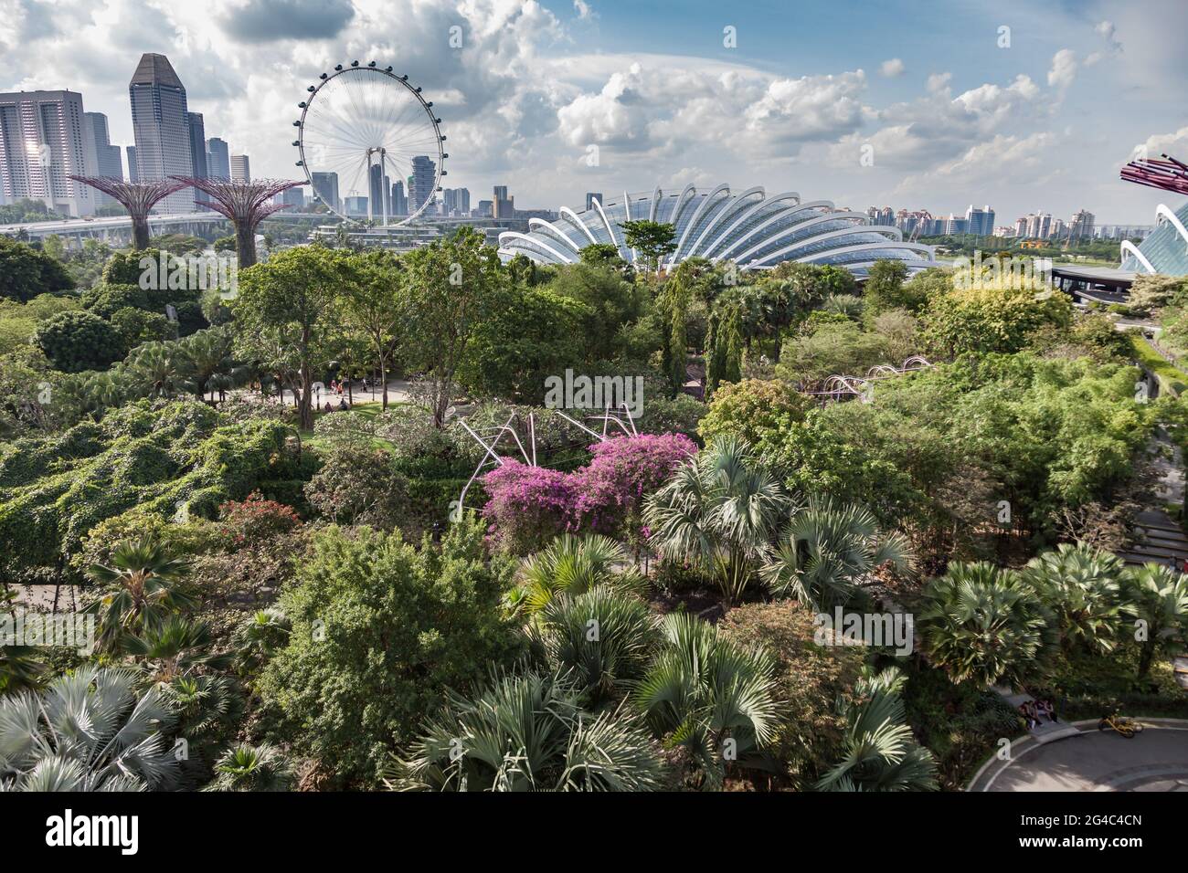 View above Gardens by the Bay, Singapore, with the Flower Dome, Singapore Flyer and city skyline Stock Photo