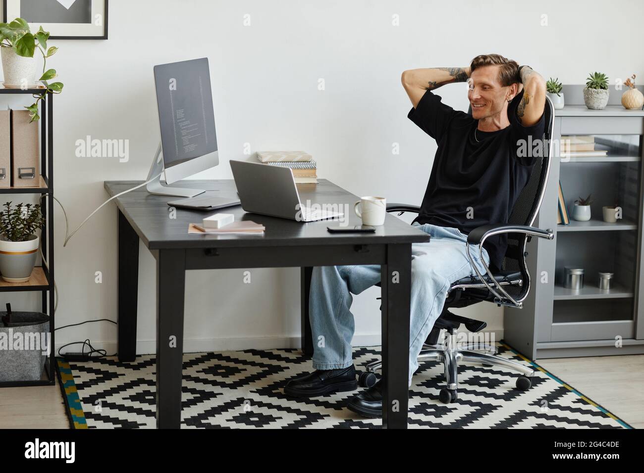 Successful computer programmer sitting at the table and working with software on computers at office Stock Photo
