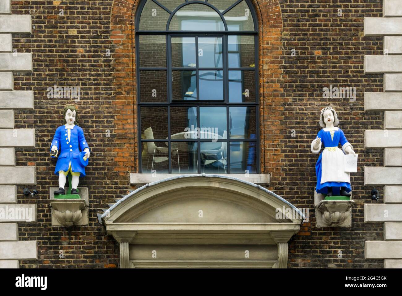 Statues of schoolchildren outside the entrance to the old St Andrews Parochial charity school in Hatton Garden, London. Stock Photo