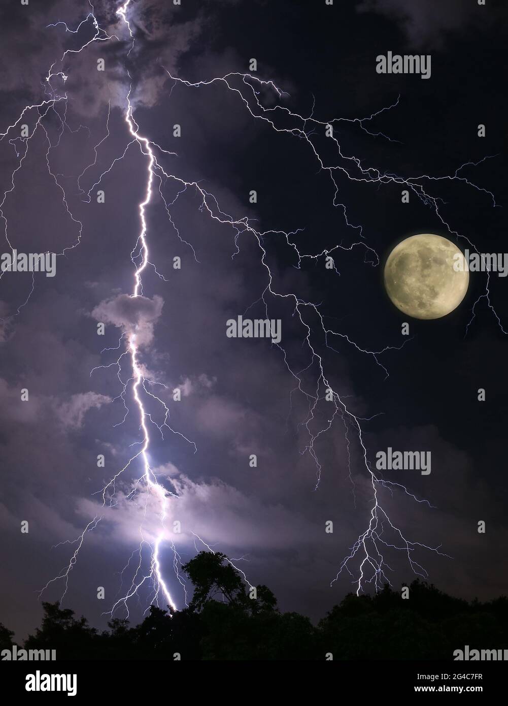 Incredible Lightning Strikes in the Night Sky with Spooky Full Moon Stock Photo