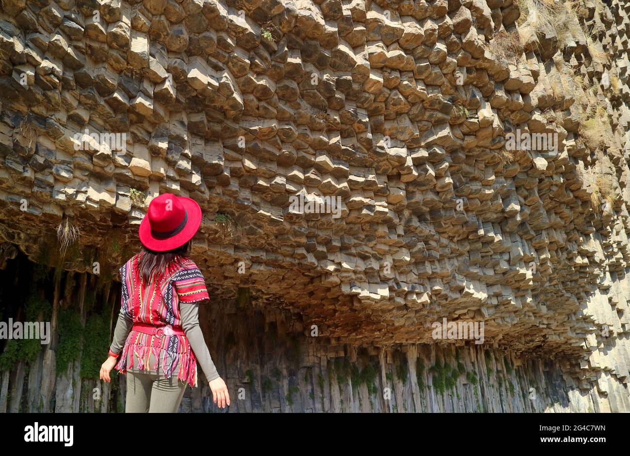 Female tourist Being Impressed by the Incredible Symphony of Stones Basalt Column Formations Along the Garni Gorge, Armenia Stock Photo
