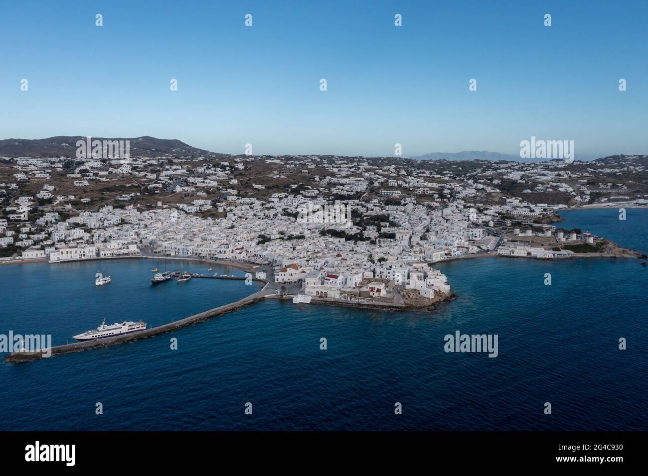 Greece, Mykonos island, Cyclades. Aerial drone view. Mikonos coastline, Chora whitewashed buildings cityscape, port, Little Venice and traditional win Stock Photo