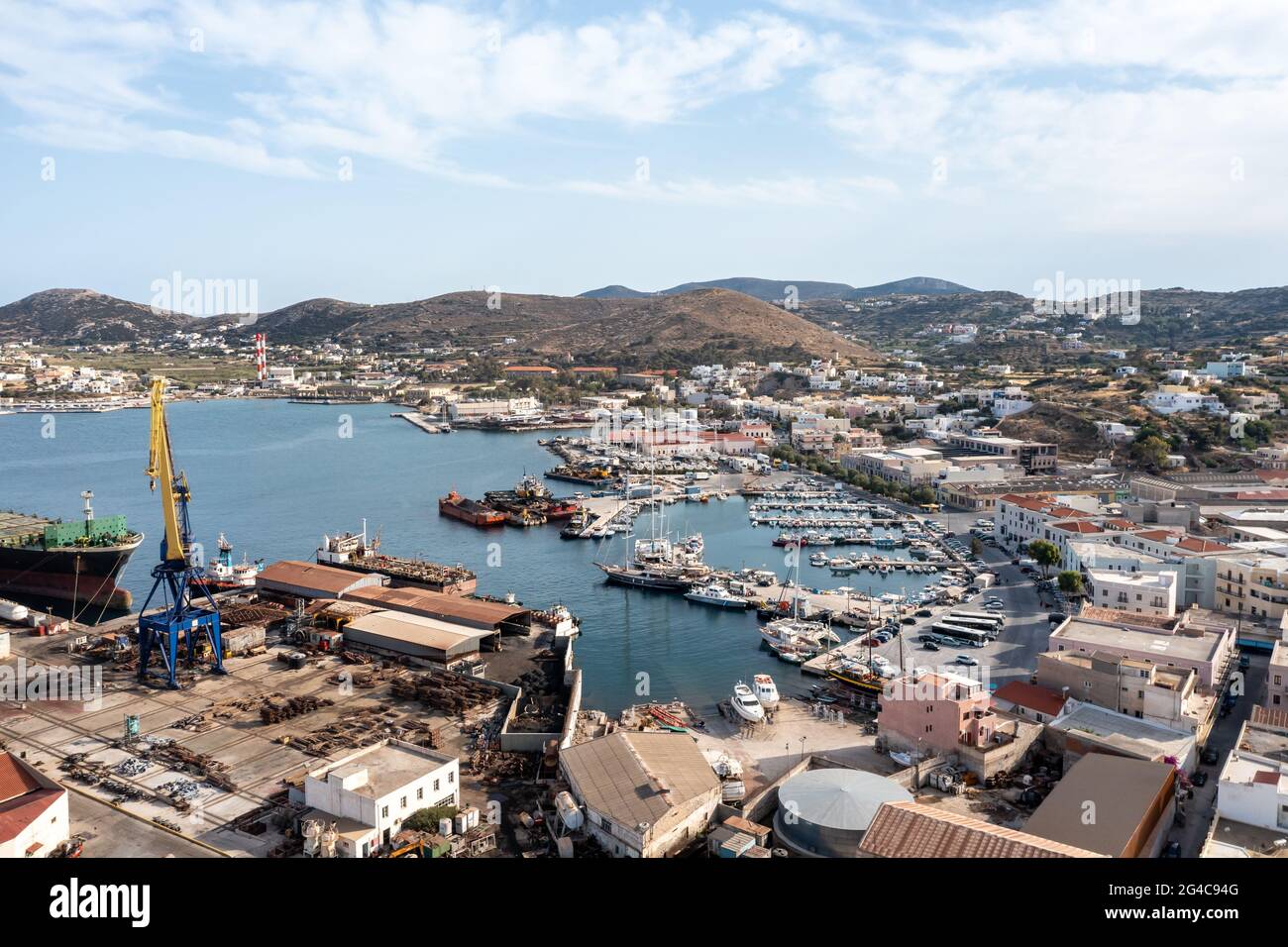 Syros island, Greece, Ermoupolis harbor aerial drone view. Boats moored at yachts marina dock. Industrial plant Neorion shipyard and cityscape, calm w Stock Photo
