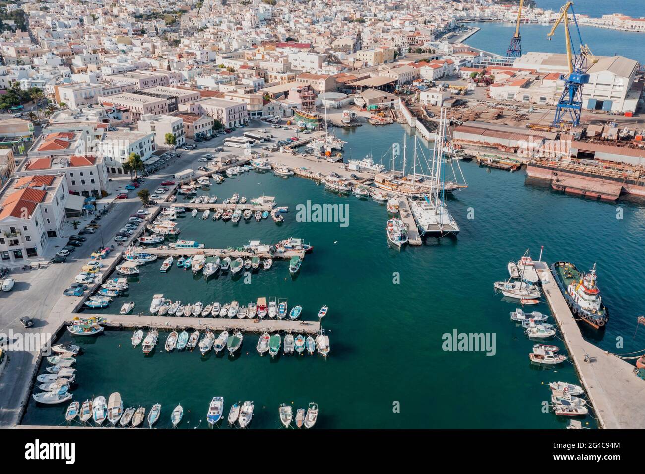 Syros island, Greece, Ermoupolis town and harbor aerial drone view. Boats moored at yachts marina dock. Industrial plant Neorion shipyard and cityscap Stock Photo