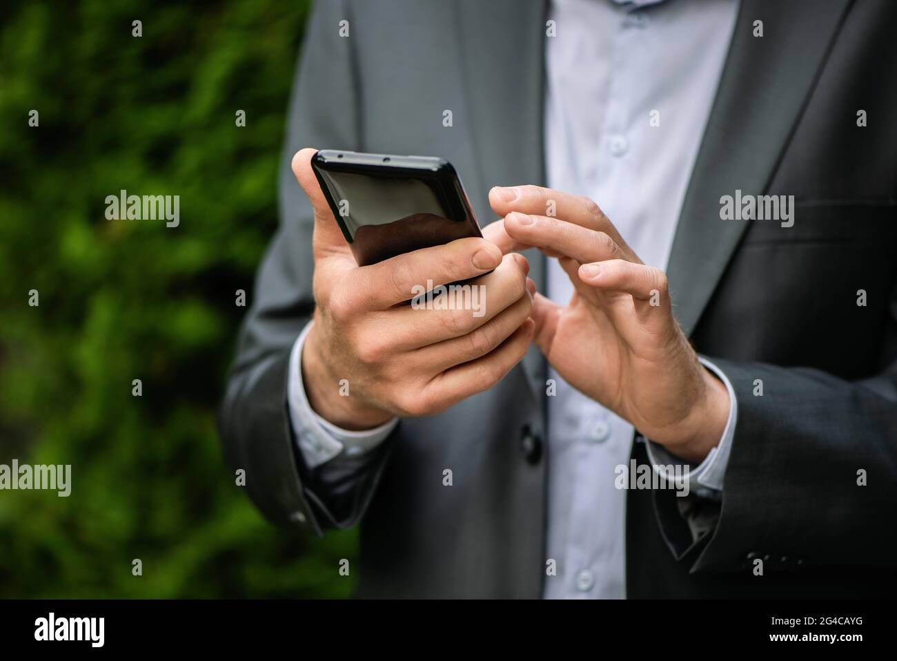 Man in a gray suit with a smartphone. Stock Photo