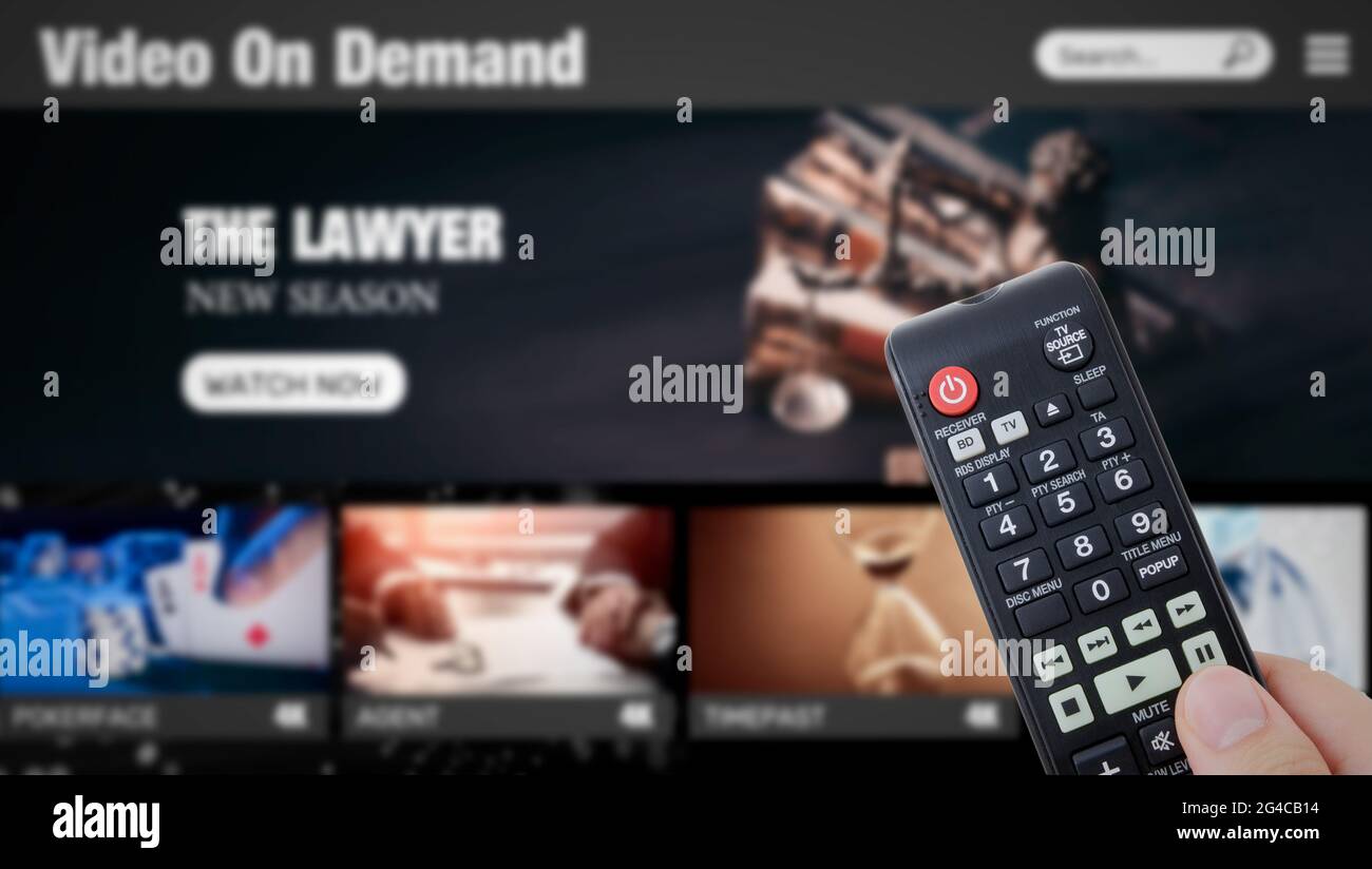 Video on demand, TV streaming, multimedia. Hand holding remote control Stock Photo