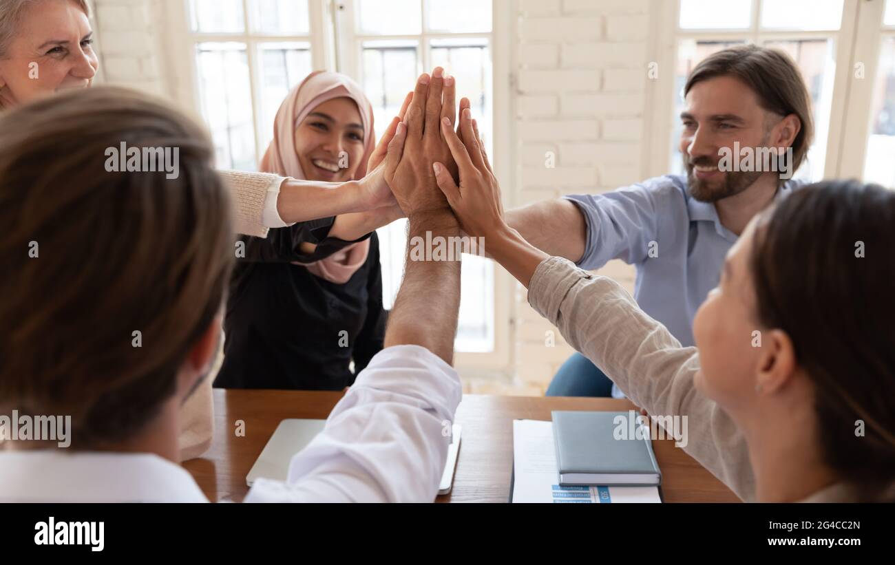Happy diverse employees team giving high five close up Stock Photo - Alamy