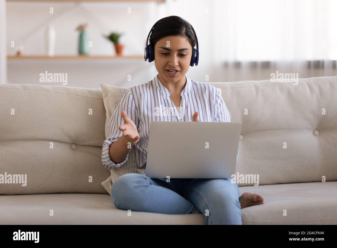 Millennial Indian woman in headphones talk on video call Stock Photo ...