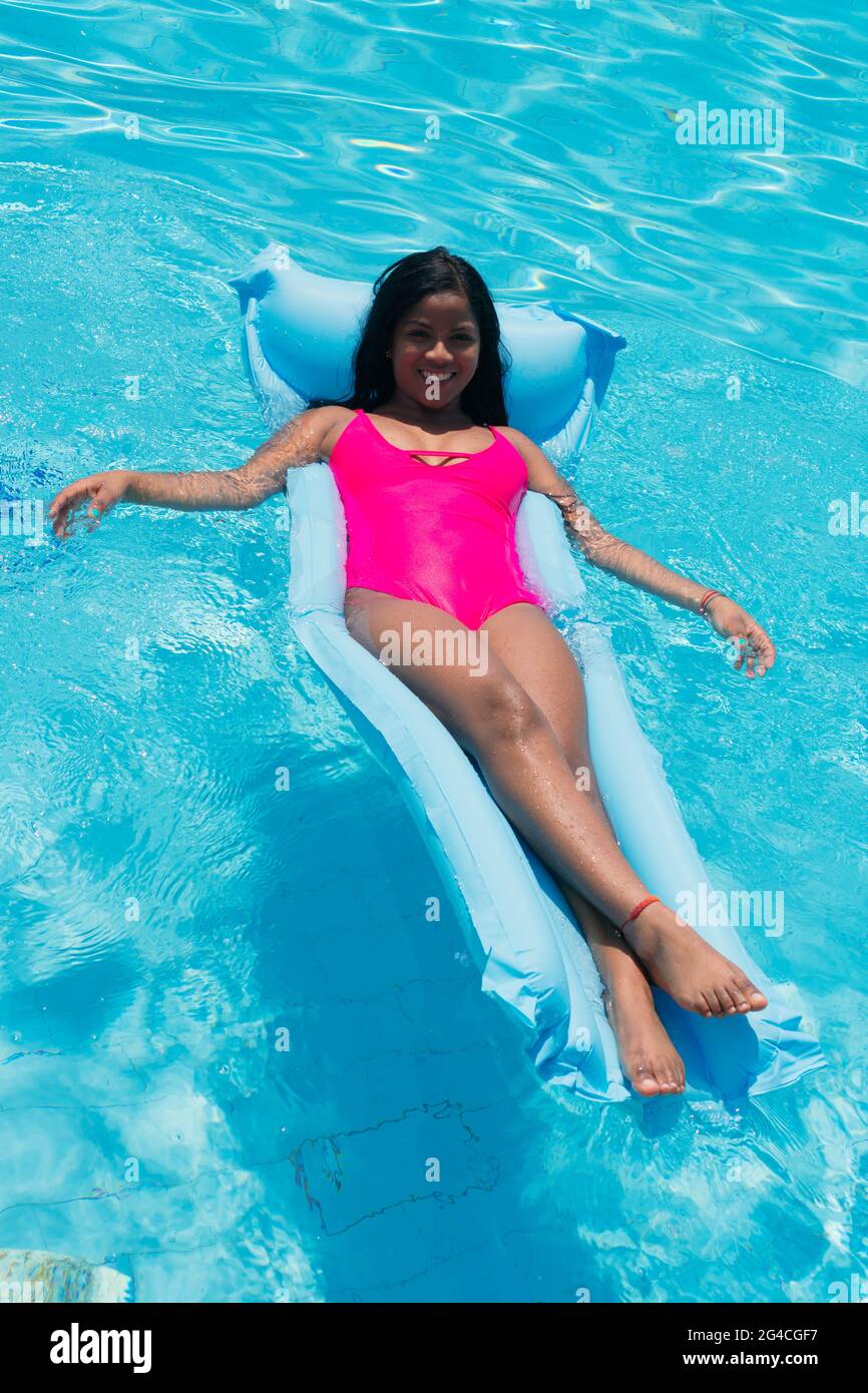 Young smiling African girl in bikini having fun on inflatable in swimming  pool Stock Photo - Alamy