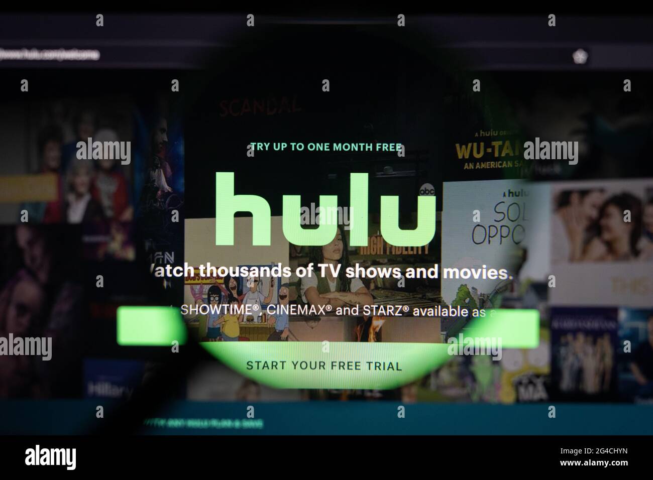 Hulu company logo on a website, seen on a computer screen through a magnifying glass. Stock Photo