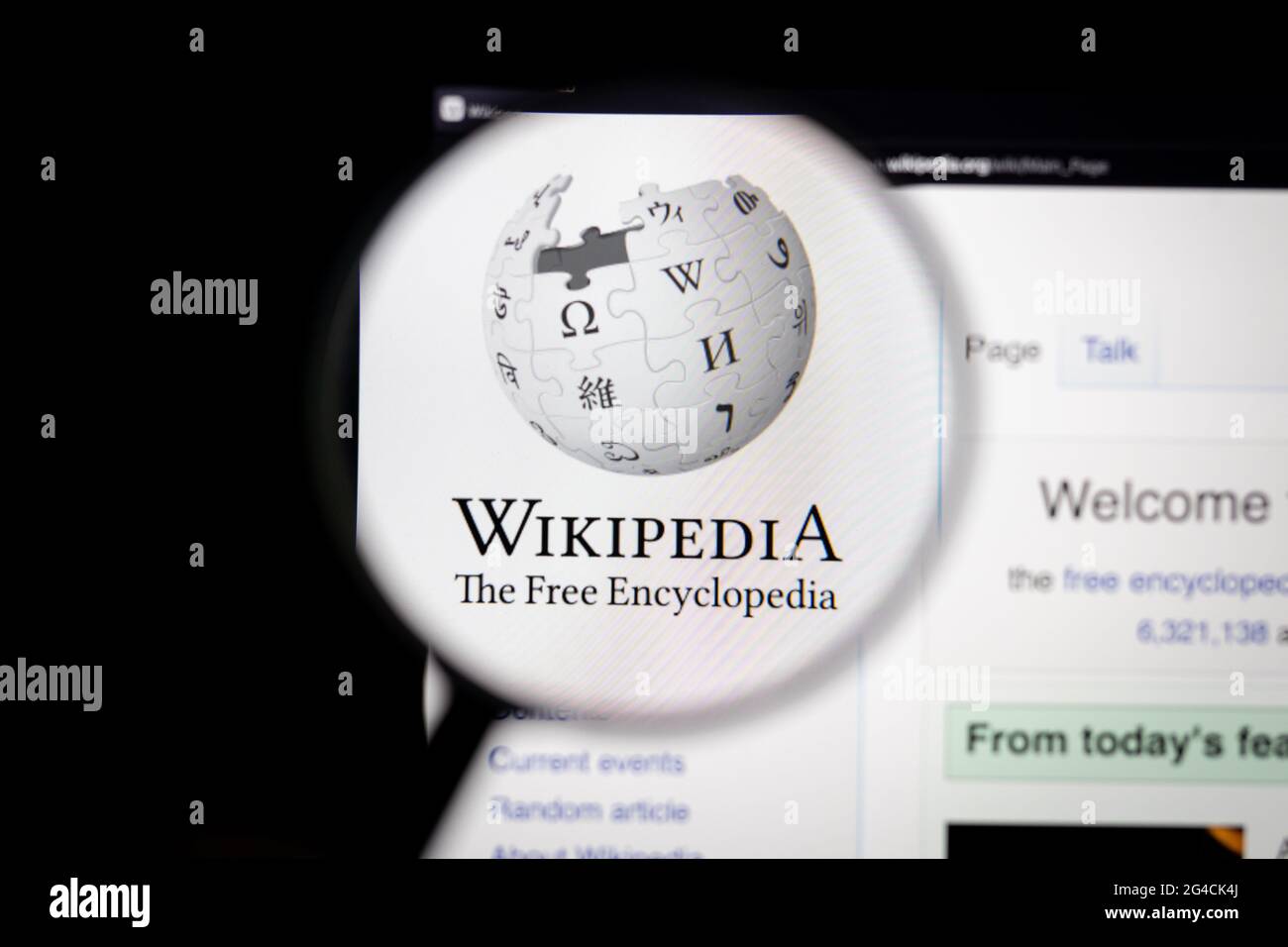 Wikipedia company logo on a website seen on a computer screen through a magnifying glass. Stock Photo
