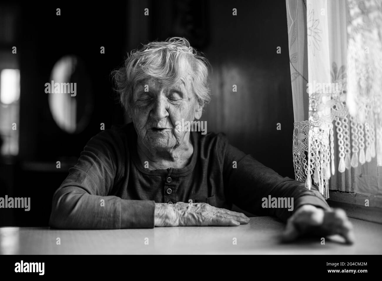 An old woman in her house. Black and white photo. Stock Photo