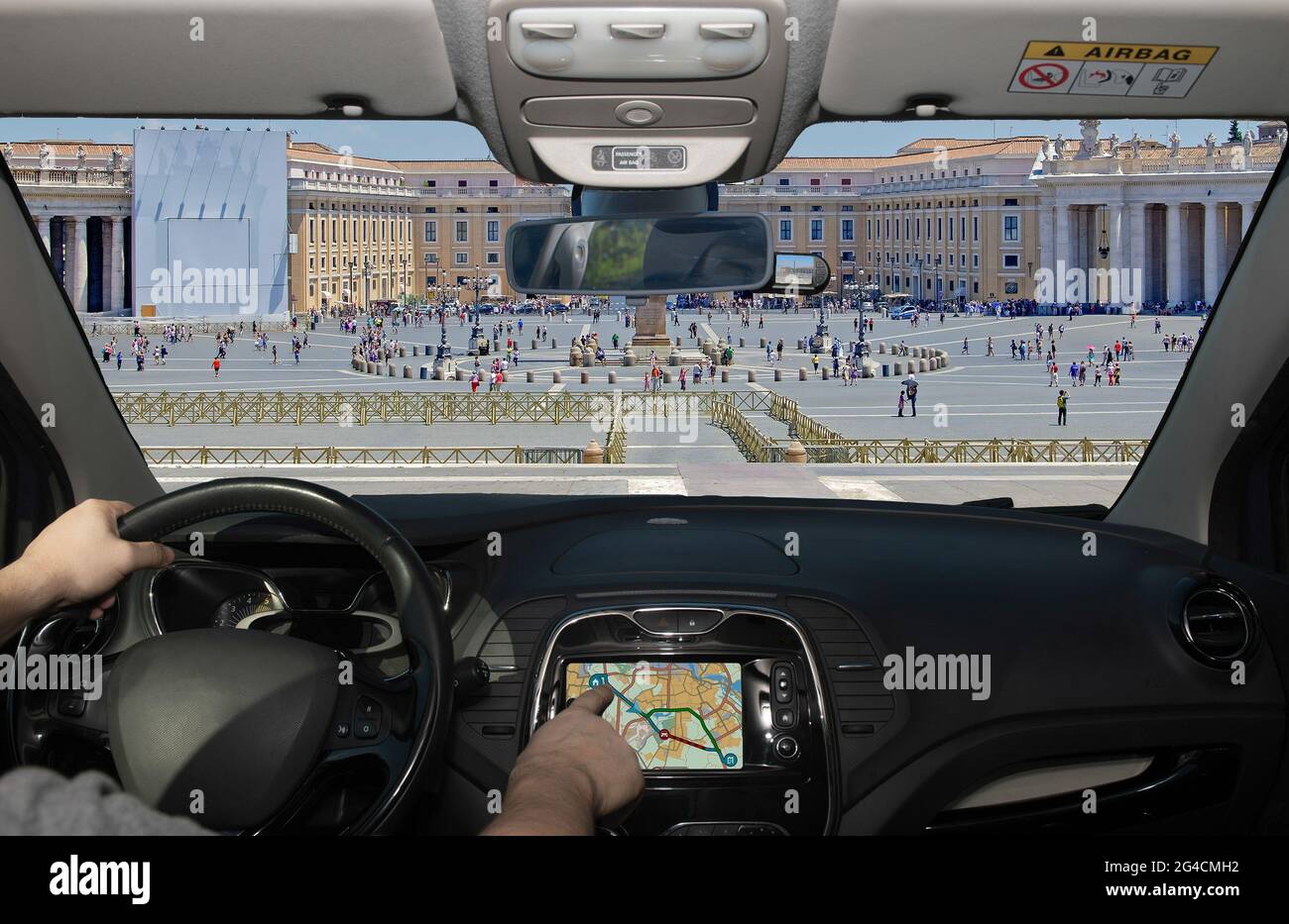 Driving a car while using the touch screen of a GPS navigation system in the scenic St. Peter's Square in Vatican City, Rome, Italy Stock Photo