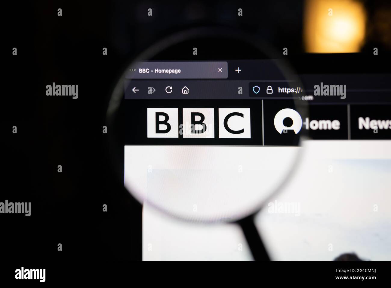 BBC company logo on a website, seen on a computer screen through a magnifying glass. Stock Photo