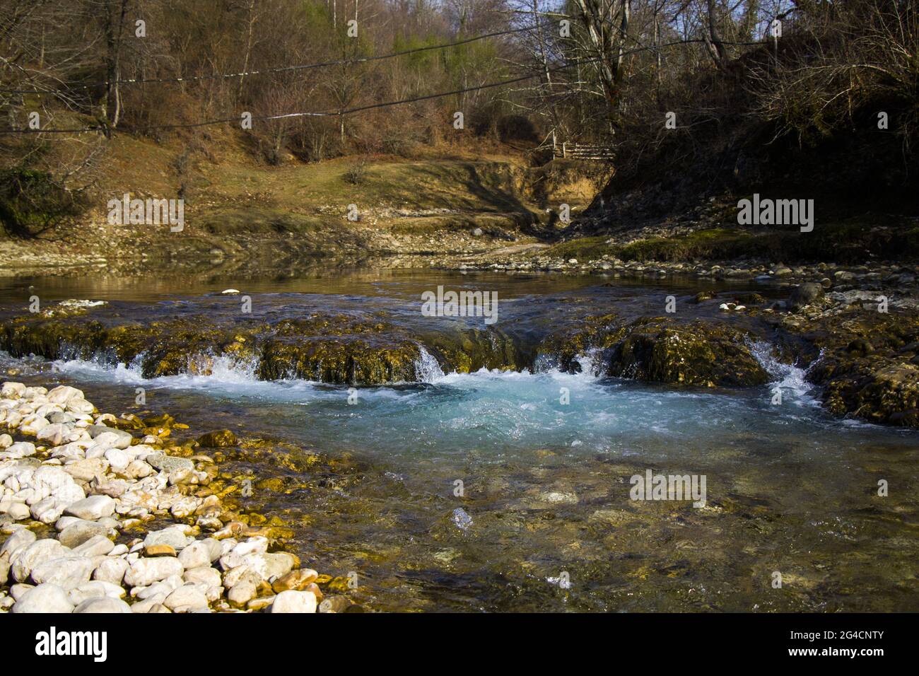River Surrounded By Rocks A beautiful view of a river surrounded by rocks and moss in Georgia ...