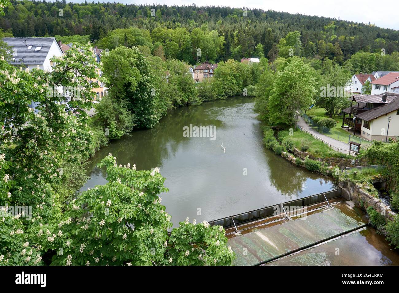 Landscape of a small dam on a river surrounded by greenery and ...