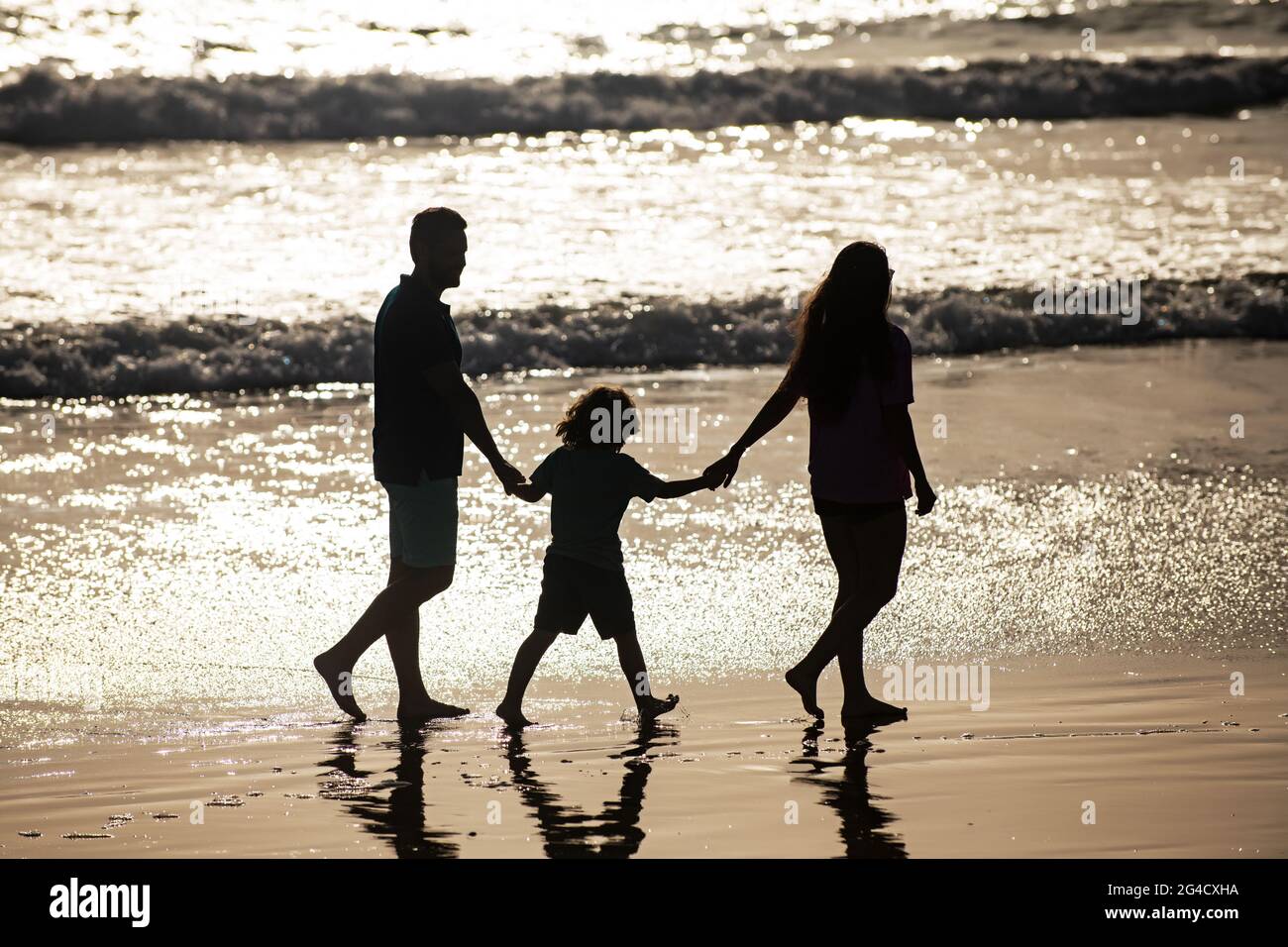 Silhouette Of Father Mother And Child Son Holding Hands And Walking On Beach Stock Photo Alamy