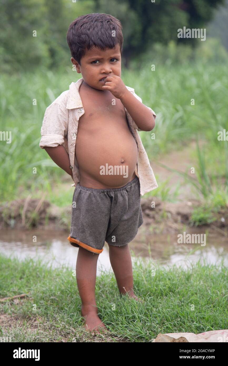 Poor Indian child in outdoor background Stock Photo