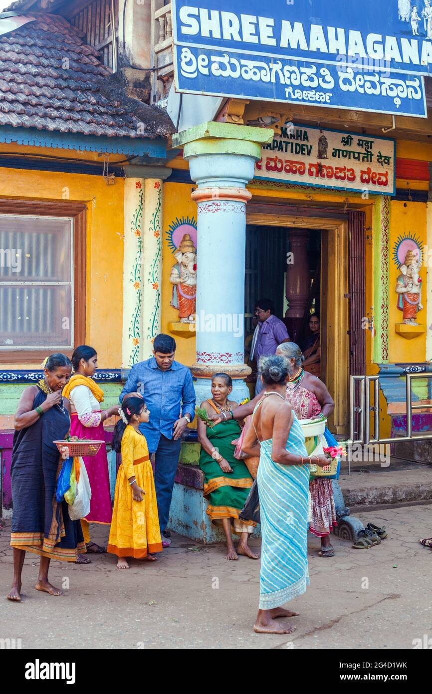 Indian females offer puja offering to worshippers at the entrance of Shree Maha Ganapati Temple, Gokarna, Karnataka, India Stock Photo