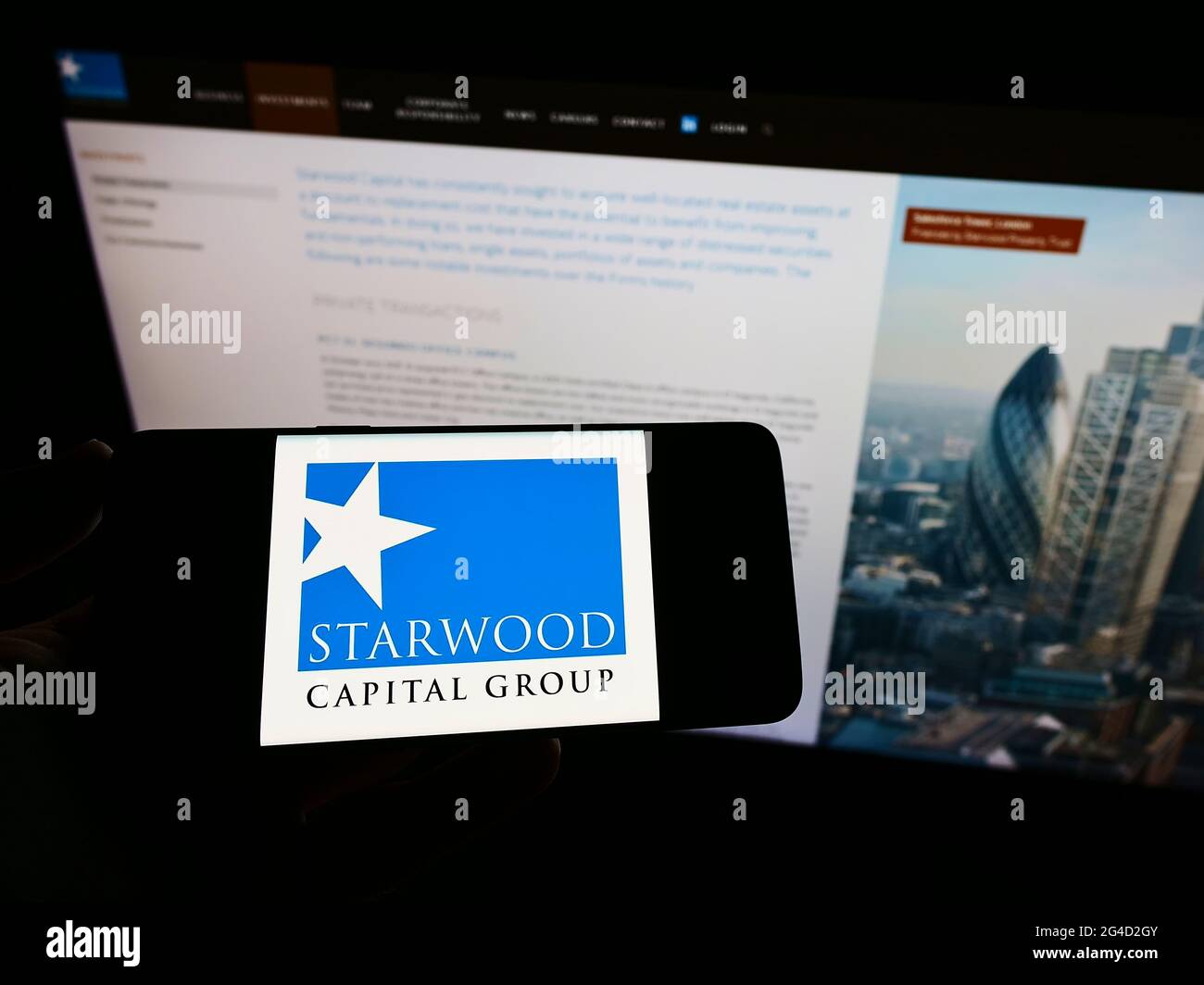 Person holding mobile phone with logo of American investment firm