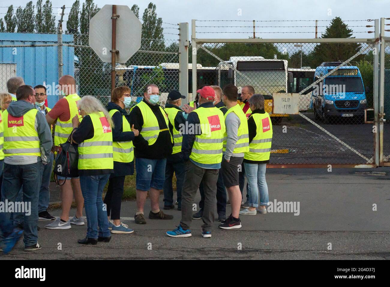 Pirmasens, Germany. 21st June, 2021. Pickets stand in front of the depot of  the bus operator QNV. The trade union Verdi has called on the employees in  the private bus industry in