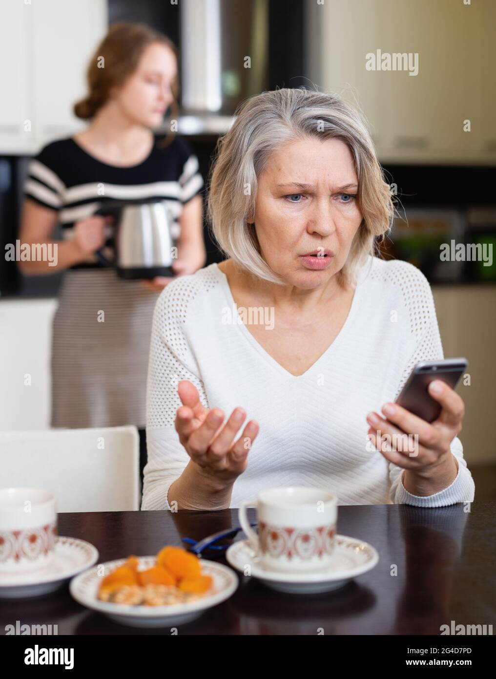 Upset woman using smartphone Stock Photo