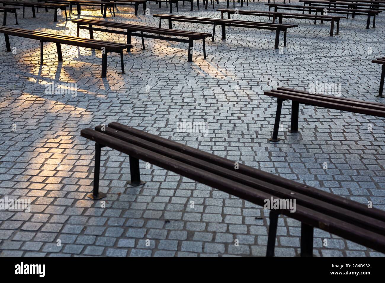 Lots of benches in a square paved with granite. Photo taken in natural soft light. A slightly shaded place. Stock Photo