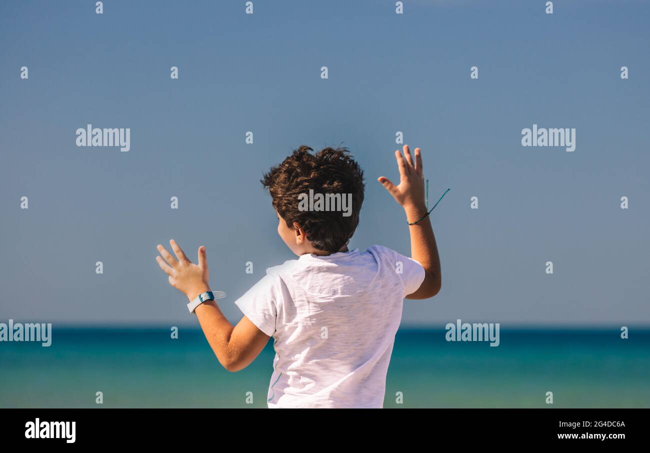 Happy Little Boy Having Fun on the Beach. Nice Child with Pleasure Spending Holidays in Summer Camp on Seashore. Happy Carefree Childhood. Stock Photo