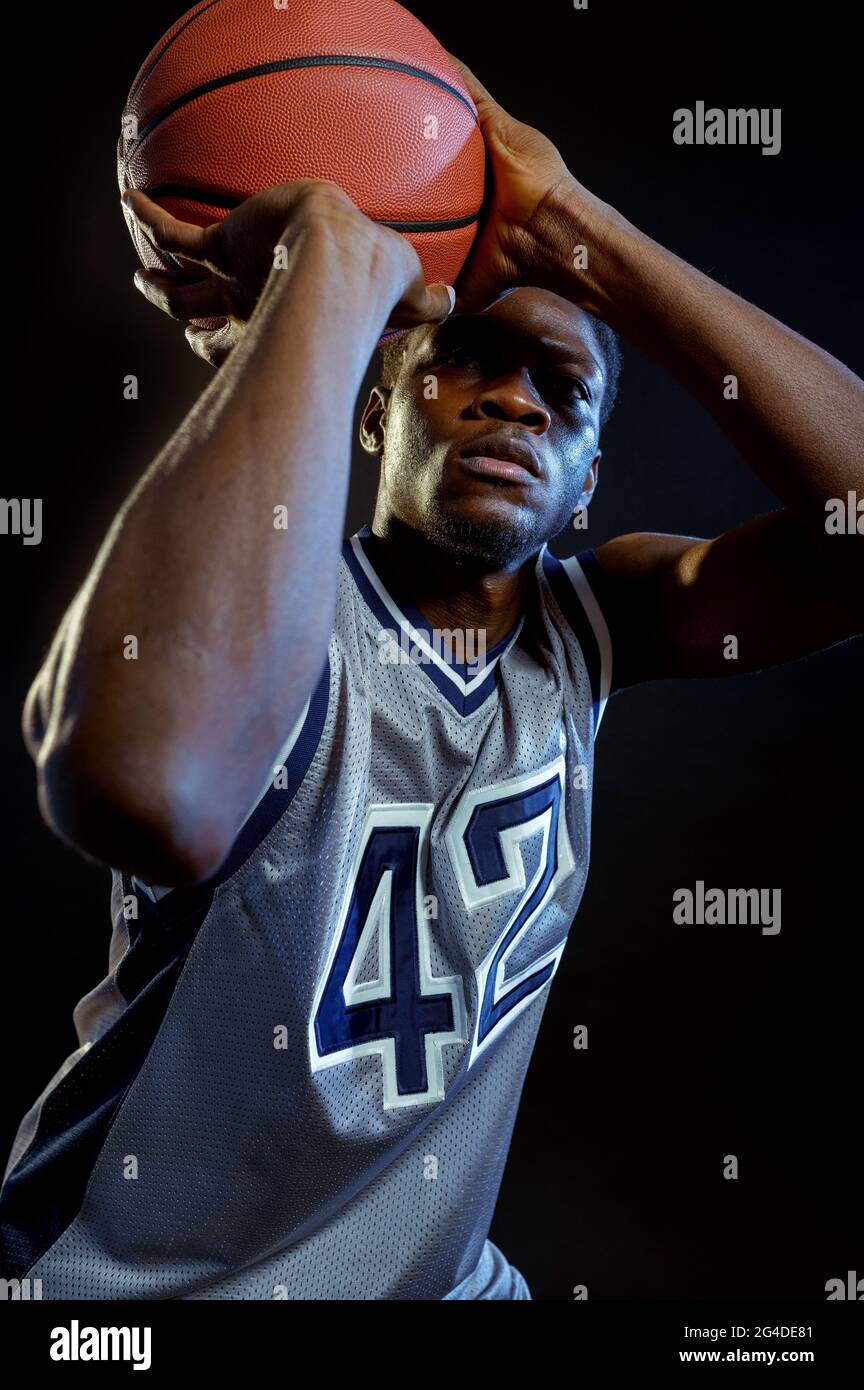 Basketball player throws a ball in studio Stock Photo Alamy