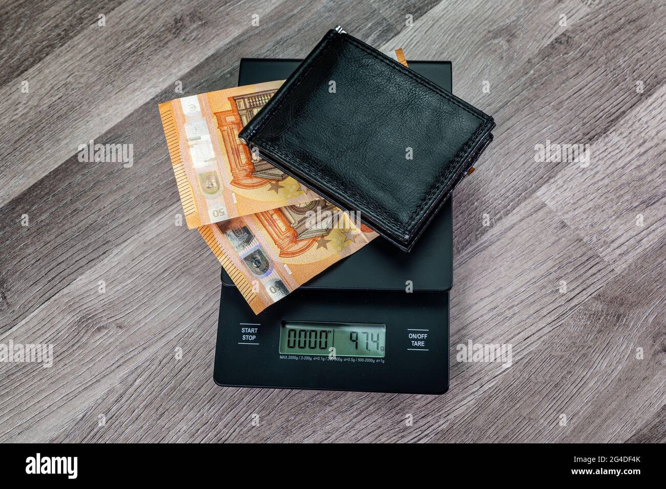 euro banknotes on top of a scale with portafolio on a wooden table ...