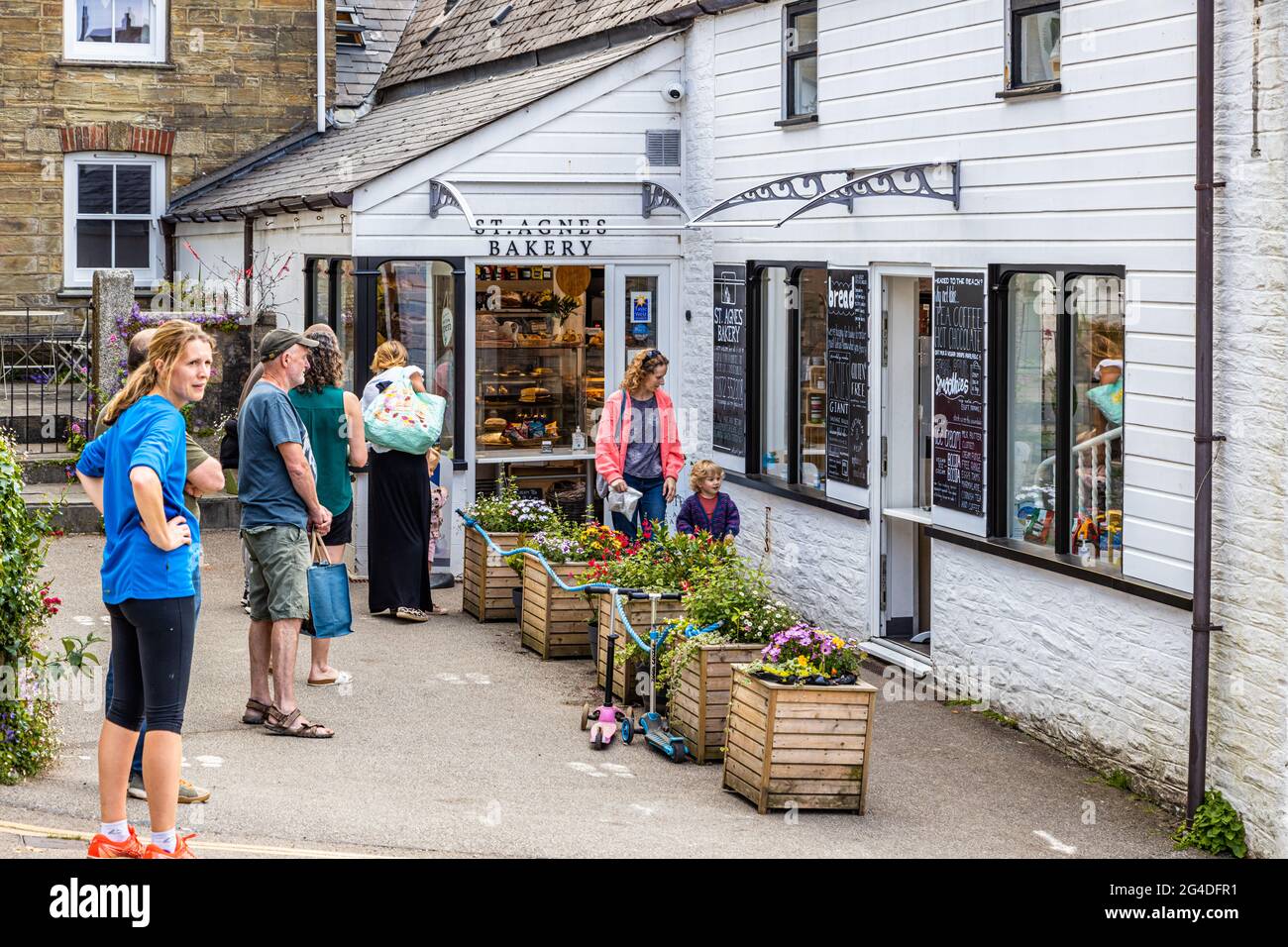 Customers social distancing outside a bakery in St Agnes Cornwall during the ongoing Covid 19 pandemic Stock Photo